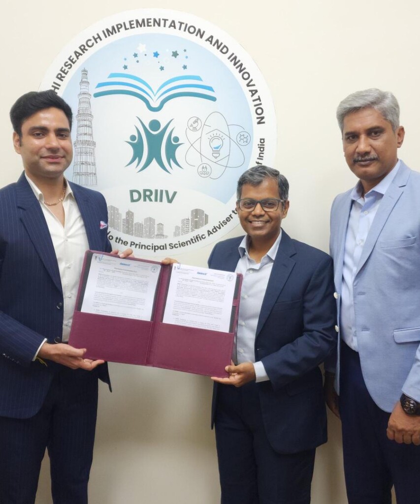 Three men in business suits pose with a binder of documents in front of a DRIV logo.